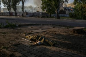 The body of an unidentified elderly woman who was hit in shelling rested on the sidewalk in Donetsk last month, days after the cease-fire. Credit Mauricio Lima for The New York Times