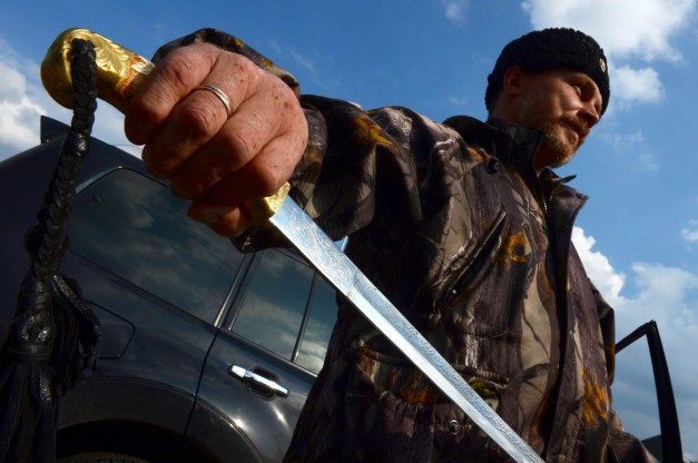 Alcalde de Pervomaisk, un comandante cosaco conocido como 'Evgeniy,' posa con su espada tradicional en la ciudad, a unos 50 km al oeste de Luhansk, en septiembre. | AFP-JIJI