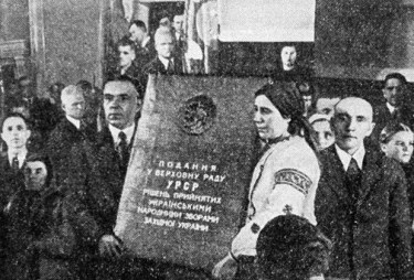 Diputados comunistas sostienen una pancarta alabando la incorporación de Ucrania occidental en la URSS.